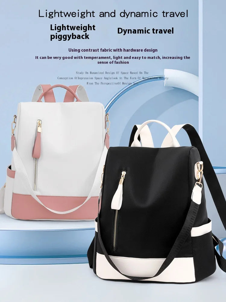 Two color-blocked backpacks displayed on a light blue studio set with promotional text at the top. One backpack is white with a pink bottom panel and handles, and the other is black with a white top and bottom panel.