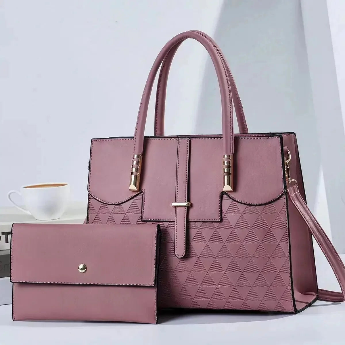 Pink handbag with matching wallet on a light background