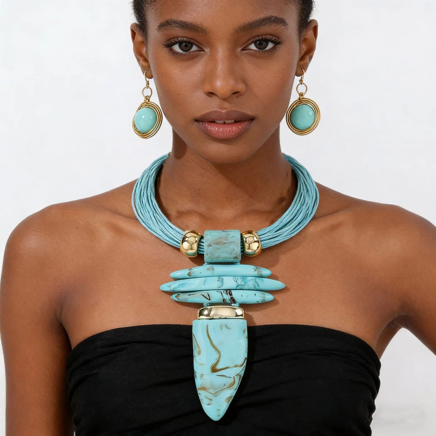 Woman wearing a turquoise necklace and earrings on a white background