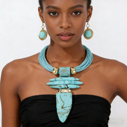 Woman wearing a turquoise necklace and earrings on a white background