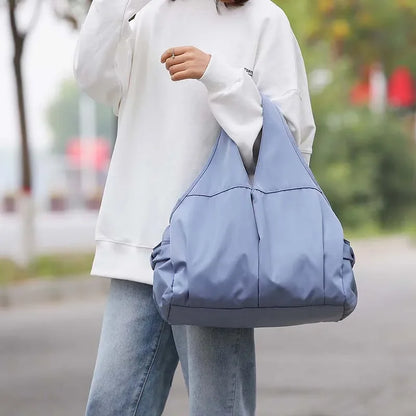 Person holding a blue bag outdoors with a blurred background