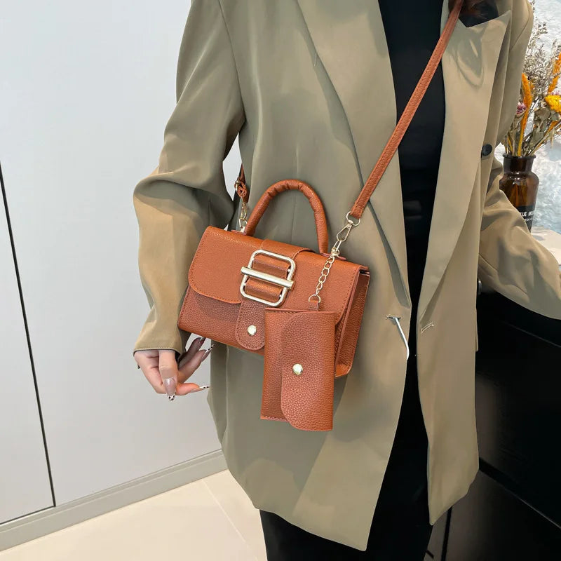 Person holding a brown handbag with a visible brand logo, wearing a beige coat.