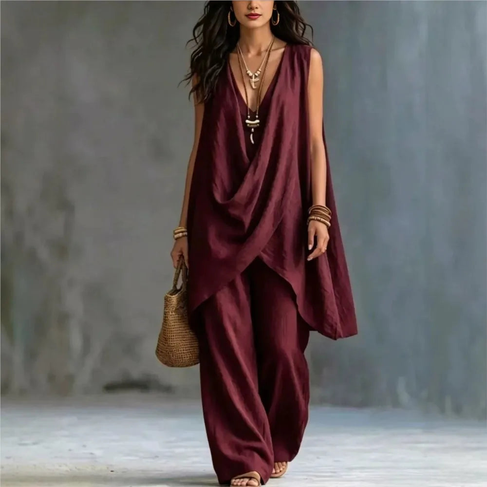 Woman wearing a burgundy sleeveless top and pants with a textured background