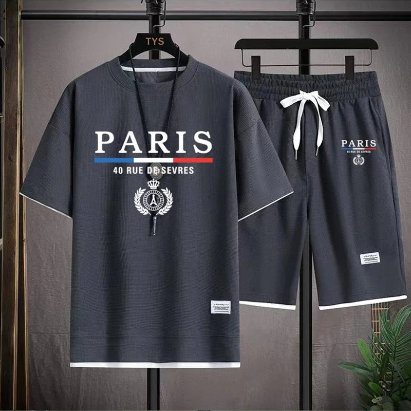 Gray 'Paris' themed t-shirt and shorts set on hangers against a neutral background.