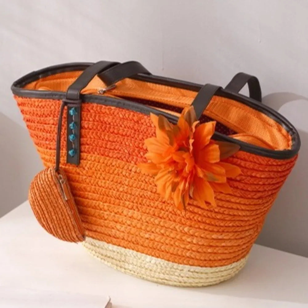 Orange straw bag with a flower decoration on a white surface