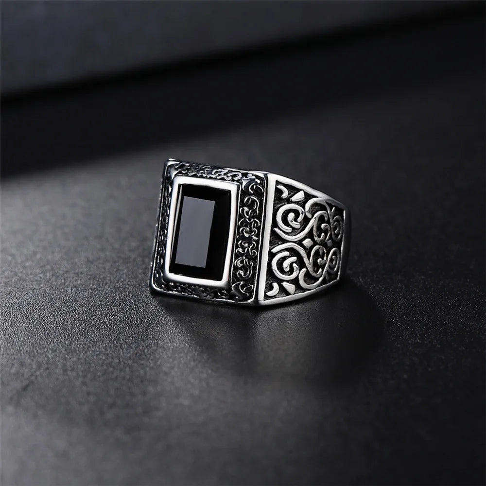 Silver ring with black stone on a dark surface