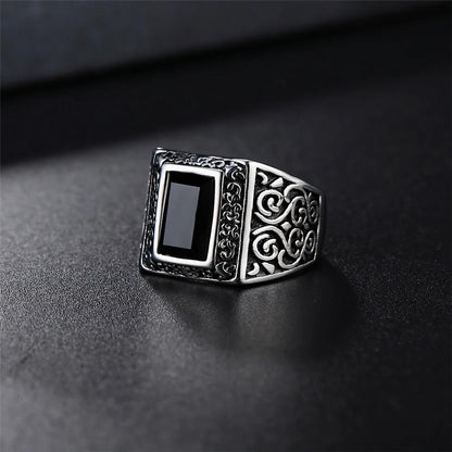 Silver ring with black stone on a dark surface