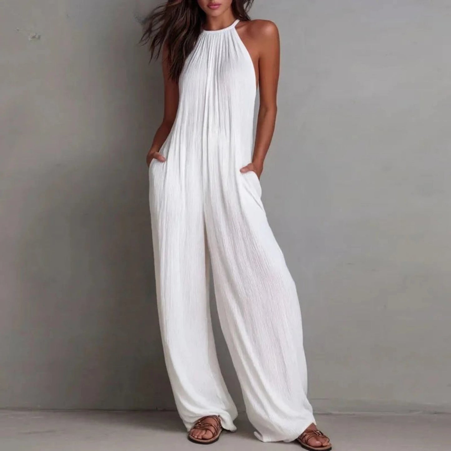 Woman wearing a white halter neck jumpsuit on a gray background with 'ZJASXMS' branding.