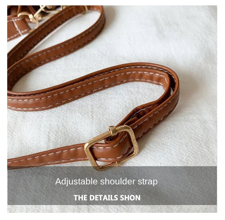 Brown leather adjustable shoulder strap with gold buckle on a white background