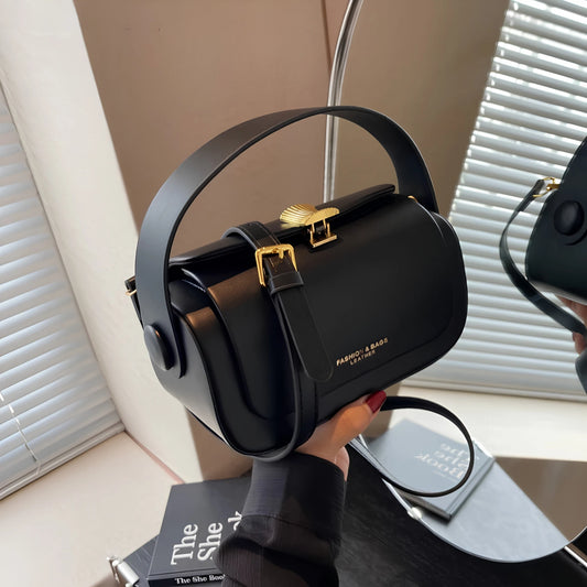 Black handbag with gold accents held by a person, with 'Moods Boutique' branding.