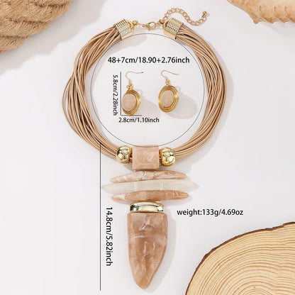 Jewelry set with necklace and earrings on a white surface with measurements displayed.