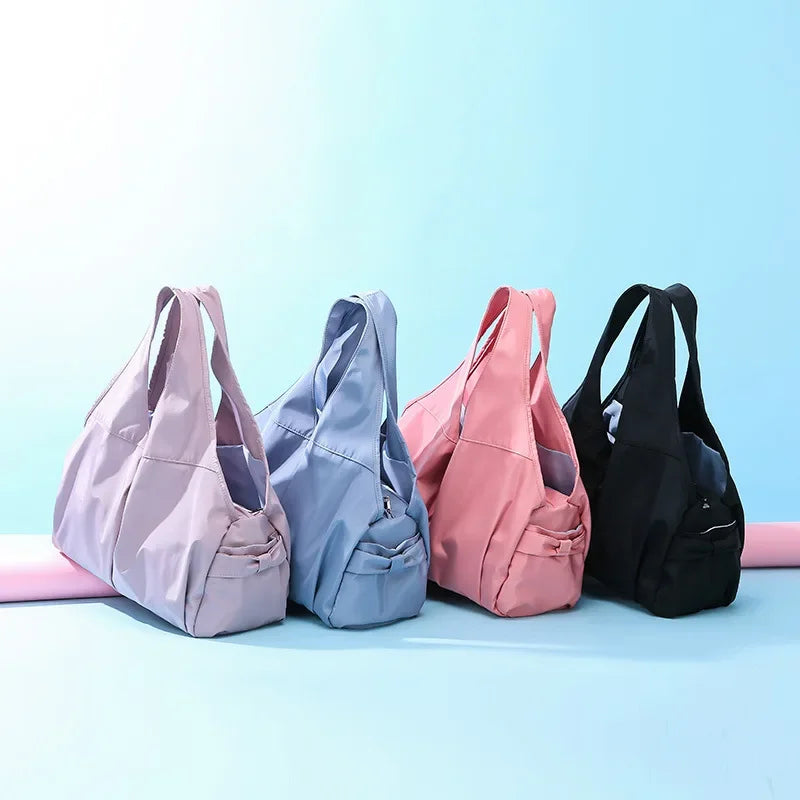 Four handbags in different colors on a light blue background