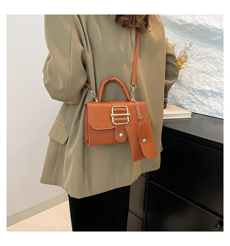 Person wearing a beige coat with an orange handbag in front of a scenic background