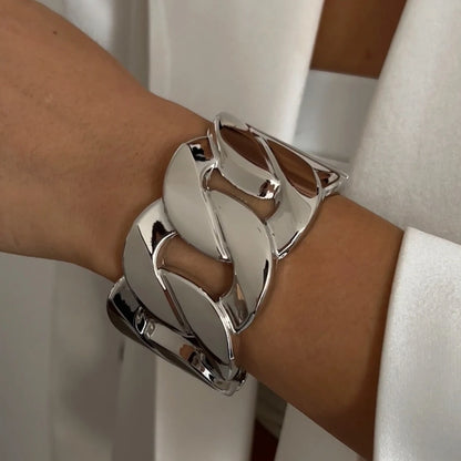 Silver bracelet on a wrist with a neutral background