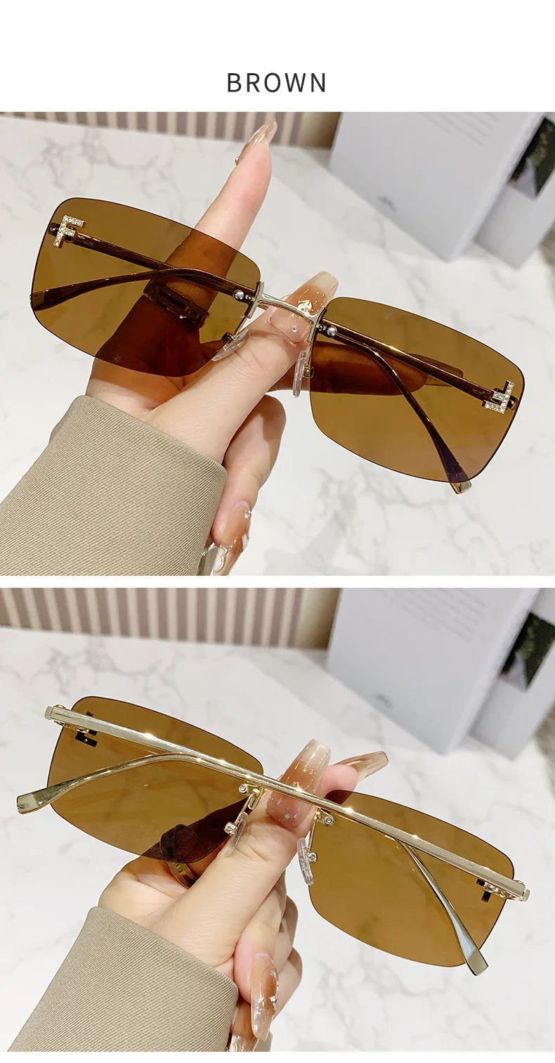 Brown sunglasses held by a hand against a neutral background