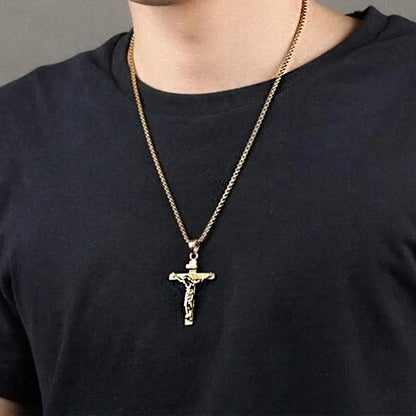 Gold cross necklace on a person wearing a black shirt