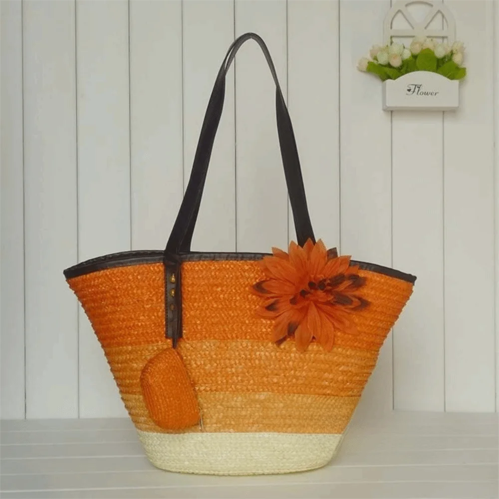 Orange straw bag with a flower decoration on a wooden surface