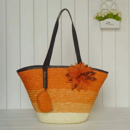 Orange straw bag with a flower decoration on a wooden surface
