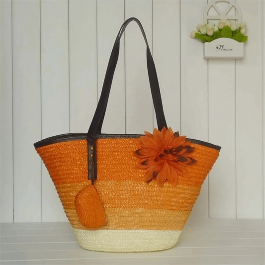Orange straw bag with a flower decoration on a wooden surface