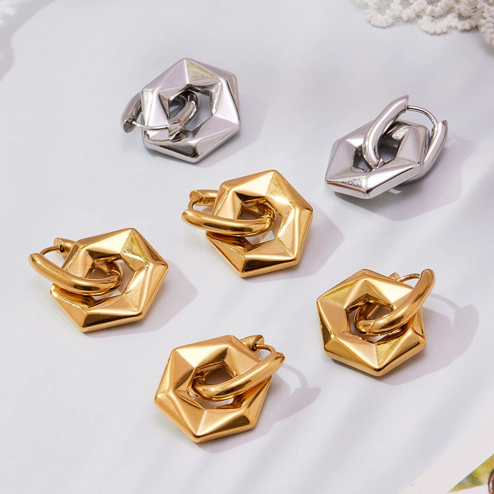 Set of gold and silver geometric earrings on a light background