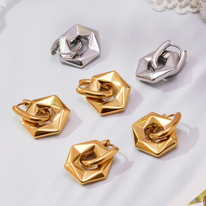 Set of gold and silver geometric earrings on a light background