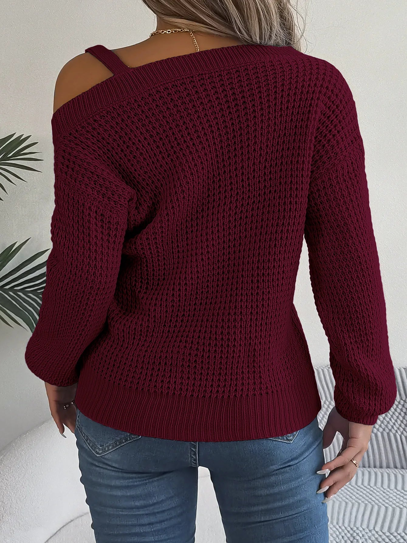 Maroon knitted sweater worn by a person with a neutral background
