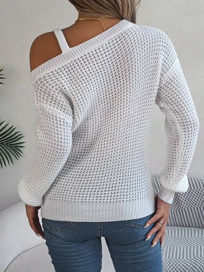 White knit sweater with cut-out shoulders worn by a person, against a neutral background.