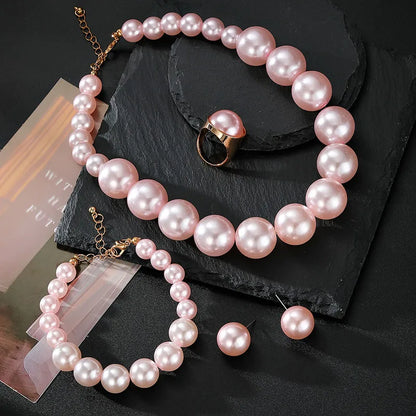 Pearl necklace and bracelet set on a dark surface with a magazine underneath.