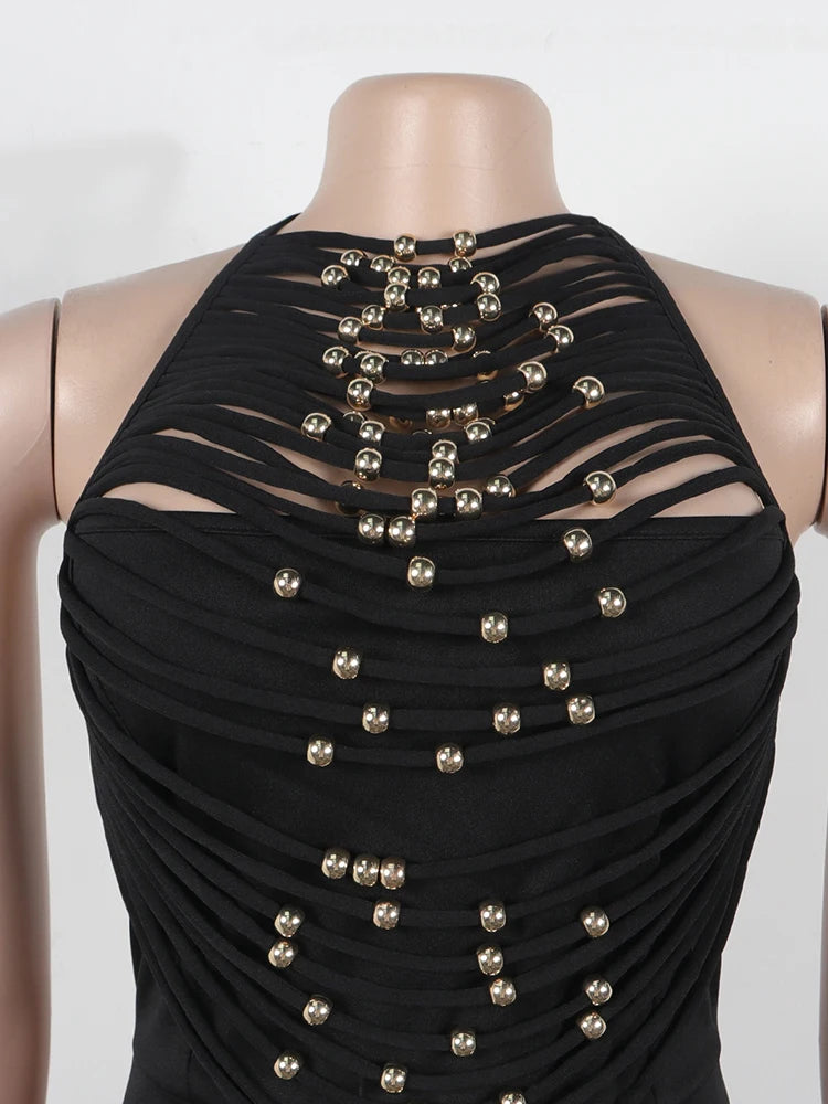 Black dress with gold bead embellishments on a mannequin against a white background