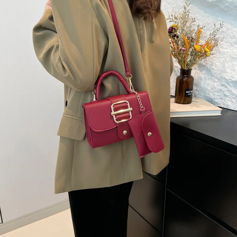 Person holding a red handbag with a neutral background