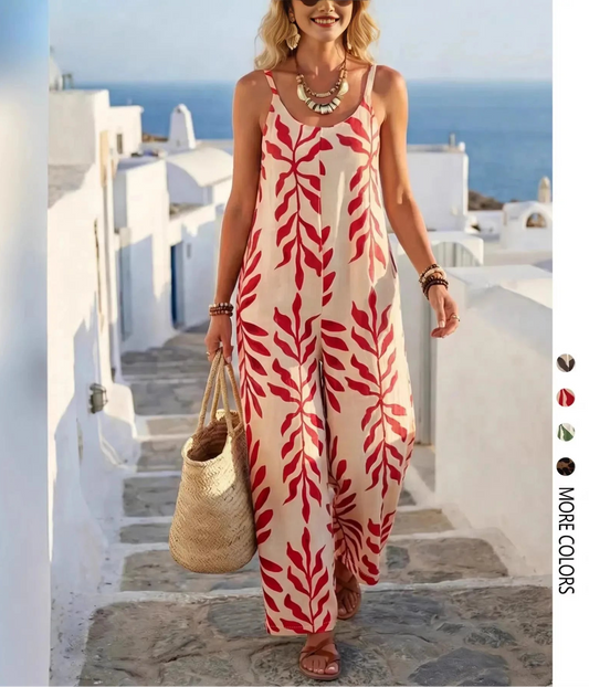 Woman in a red and white patterned jumpsuit standing on a sunlit staircase with ocean view.