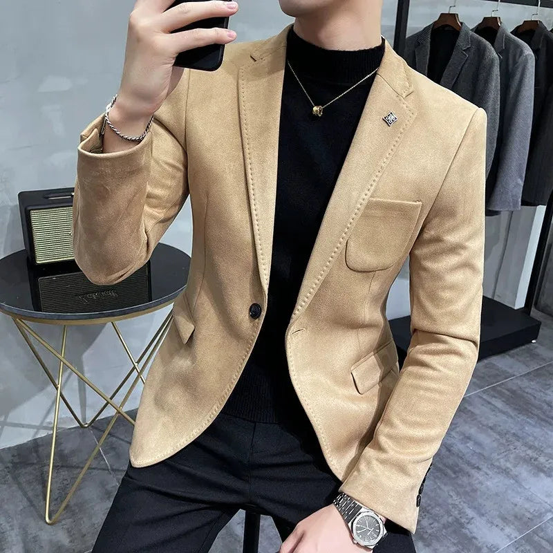 Person wearing a beige blazer taking a mirror selfie in a clothing store.
