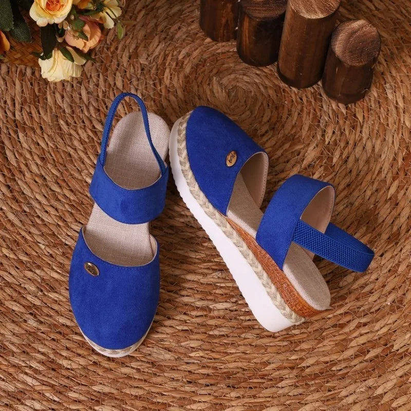 Blue sandals with white soles on a woven mat