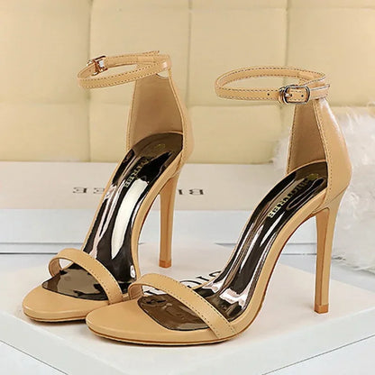 Beige high-heeled sandals with clear straps on a light background