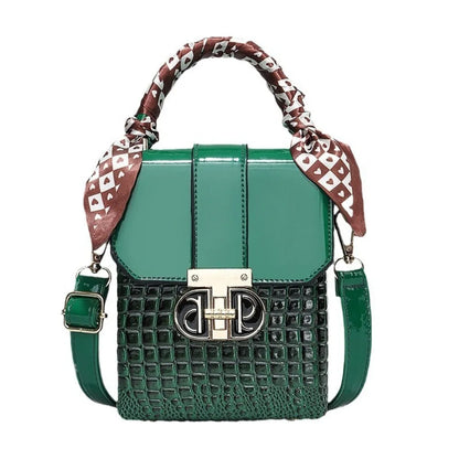 Green handbag with patterned strap on a white background
