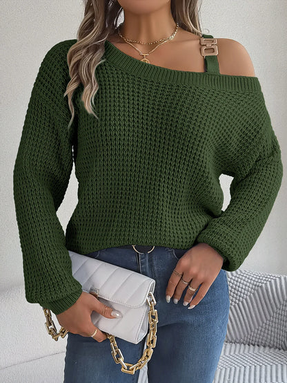 Person wearing a green sweater with a white clutch and gold chain.