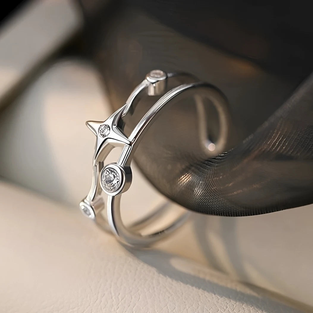 Silver ring with diamond accents on a reflective surface