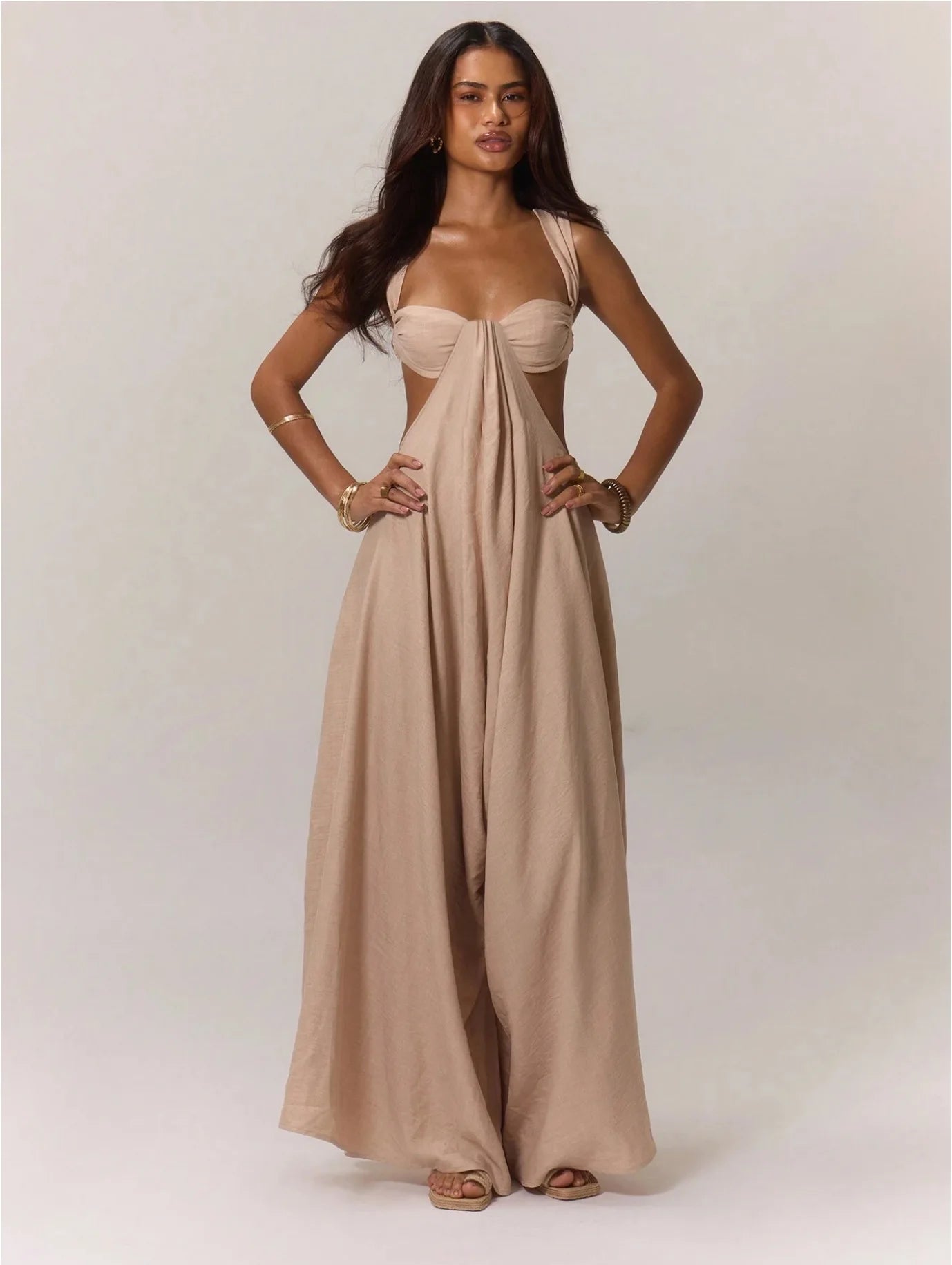 Woman wearing a beige dress with a plain background