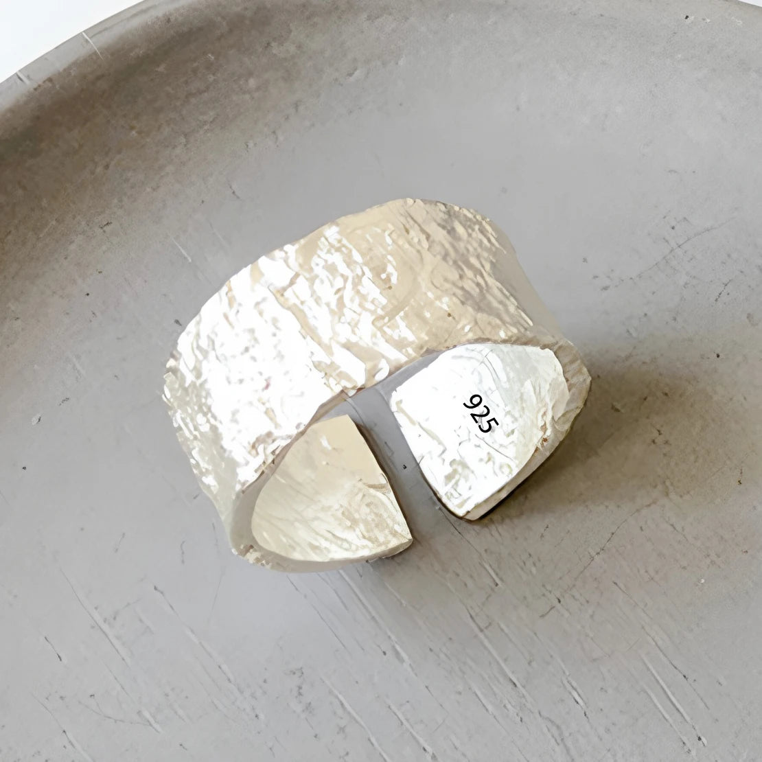 Raw silver bar with '925' stamp on a light gray background