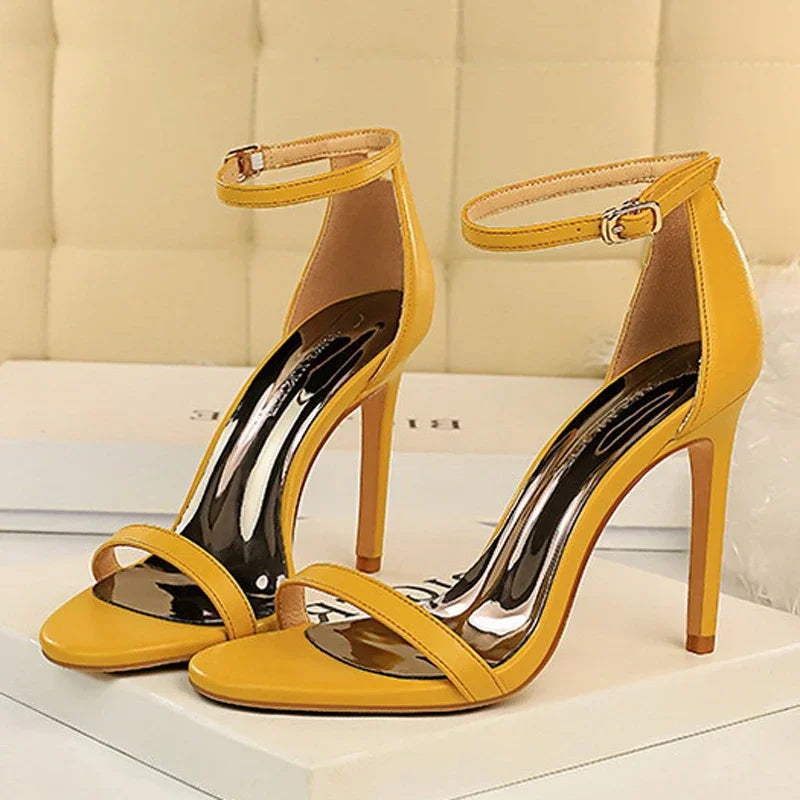 Yellow high-heeled sandals with open design on a light background