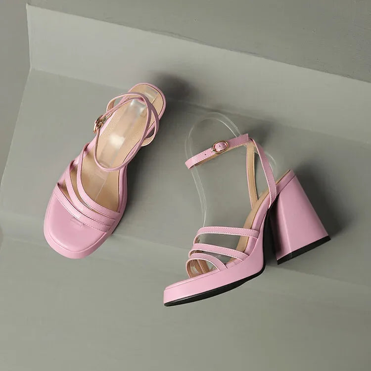 Pair of pink high-heeled sandals on a light gray background