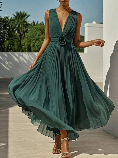 Green dress with a floral detail being modeled outdoors.