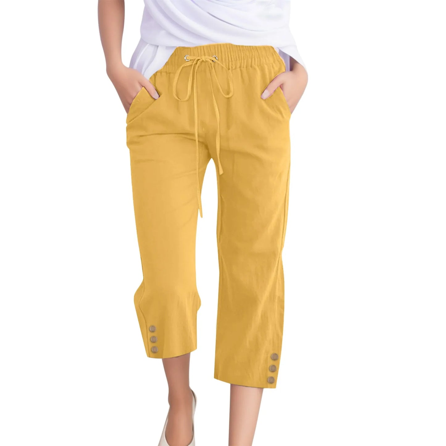Yellow capri pants worn by a person on a white background