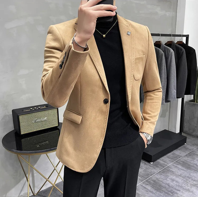 Person wearing a beige blazer over a black shirt in a clothing store.
