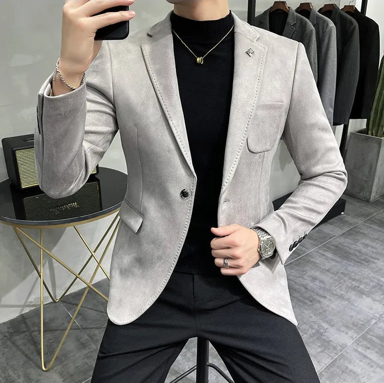Person wearing a light gray blazer over a black shirt in a clothing store.