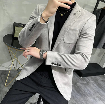 Person wearing a gray blazer and black pants in an indoor setting