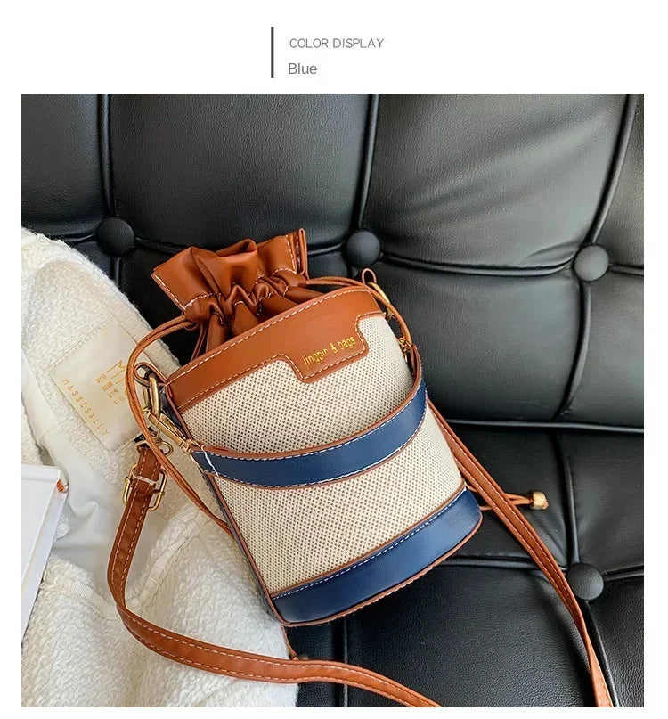Multicolored handbag with brown, blue, and beige accents on a car seat.