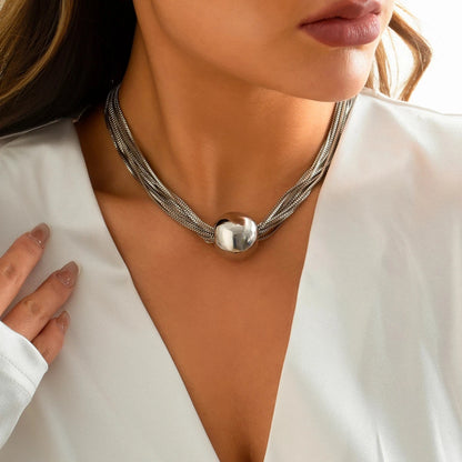 Silver-tone layered chain statement necklace featuring multiple slender strands and a polished rounded metal centerpiece.