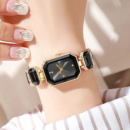 Black and gold watch on a wrist with a blurred background