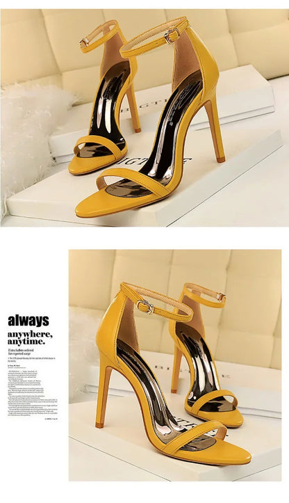 Yellow high-heeled shoes with clear straps on a white surface.